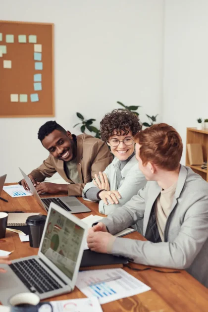 A work meeting where three team members look happy engaging with each other